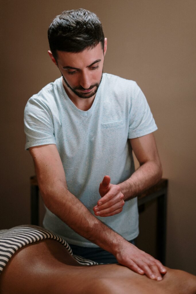 A male masseur performing a relaxing massage therapy in a calming spa environment.
